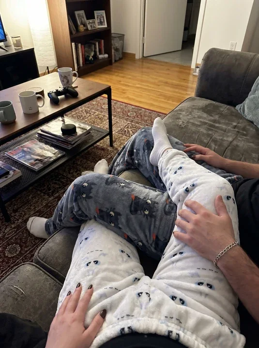Casal no sofá com as calças de pijama de dragão