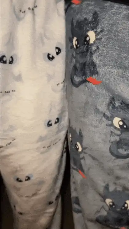 Calça branca e calça cinza do pijama de dragão lado a lado